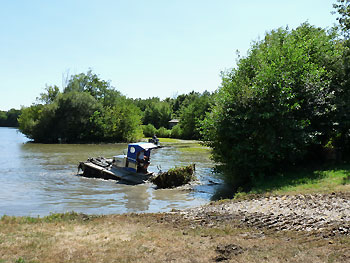 Retrait de la jussie à l'aide de machines amphibies © Estèle Guénin https://cdnfiles1.biolovision.net/vienne.lpo.fr/userfiles/travaux-jussie-2013.jpg